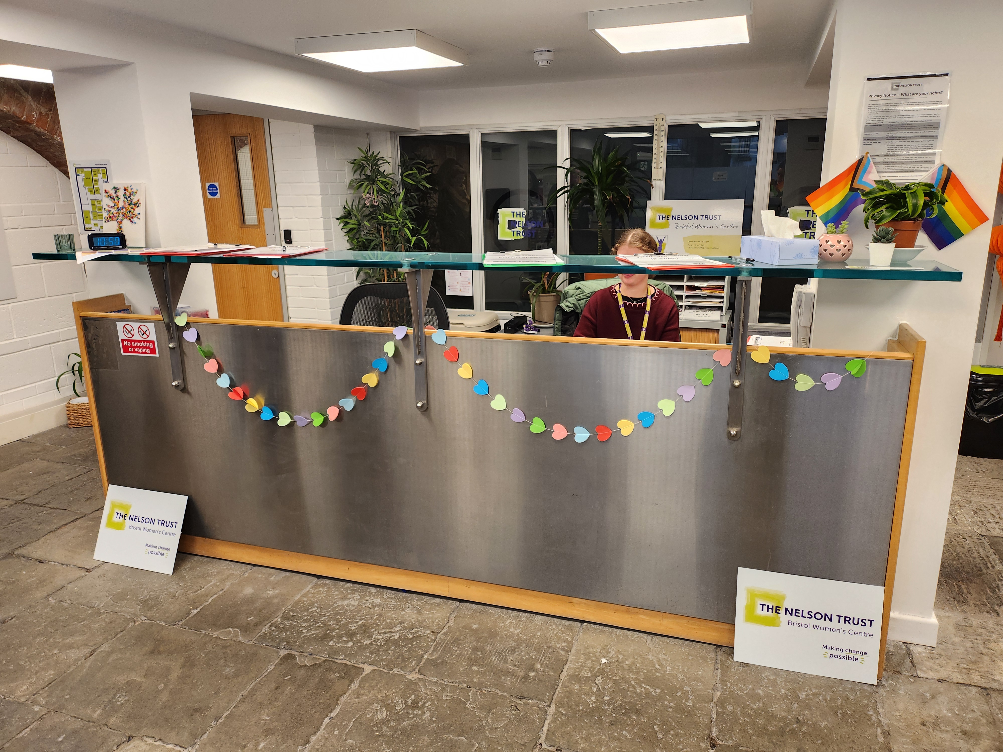 Welcome to the Bristol Women's Centre Reception area. A warm and welcoming front desk with heart cut outs as decorations across the front.