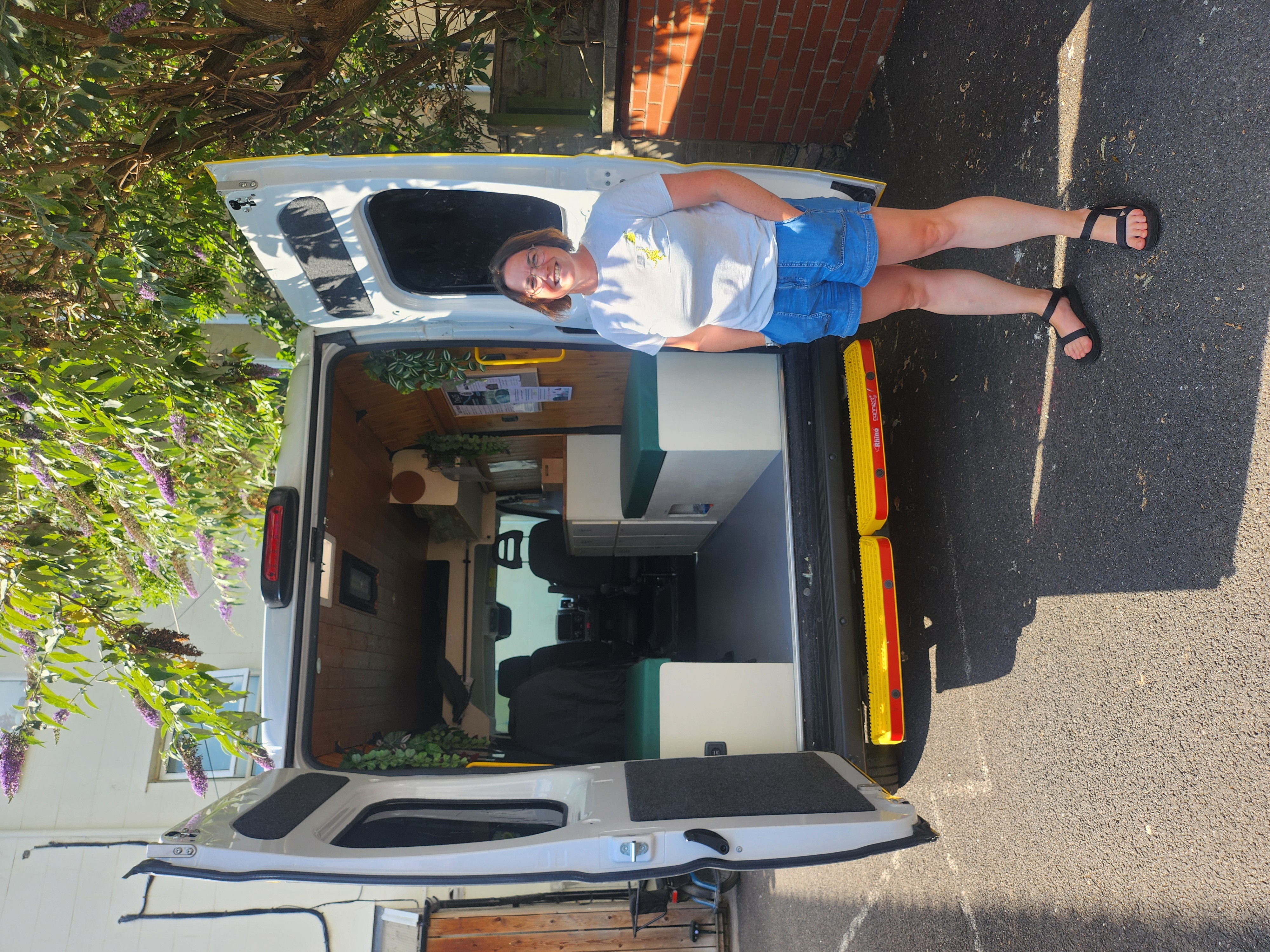 Rachel Collins-White, Operations Manager at One25, standing by the night outreach van which welcomes women who street sex work in Bristol woman smiling and standing at the back of the van which has it's back doors open